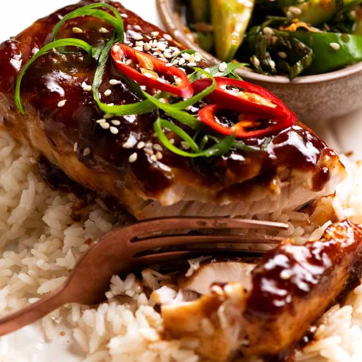 Close up of Asian Glazed Baked Barramundi on coconut rice with a side of cucumber salad