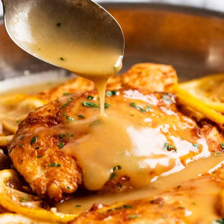 Chicken Francese sauce being poured over chicken