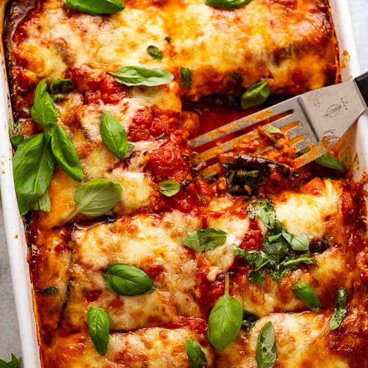 White baking dish with Eggplant Parmigiana, fresh out of the oven