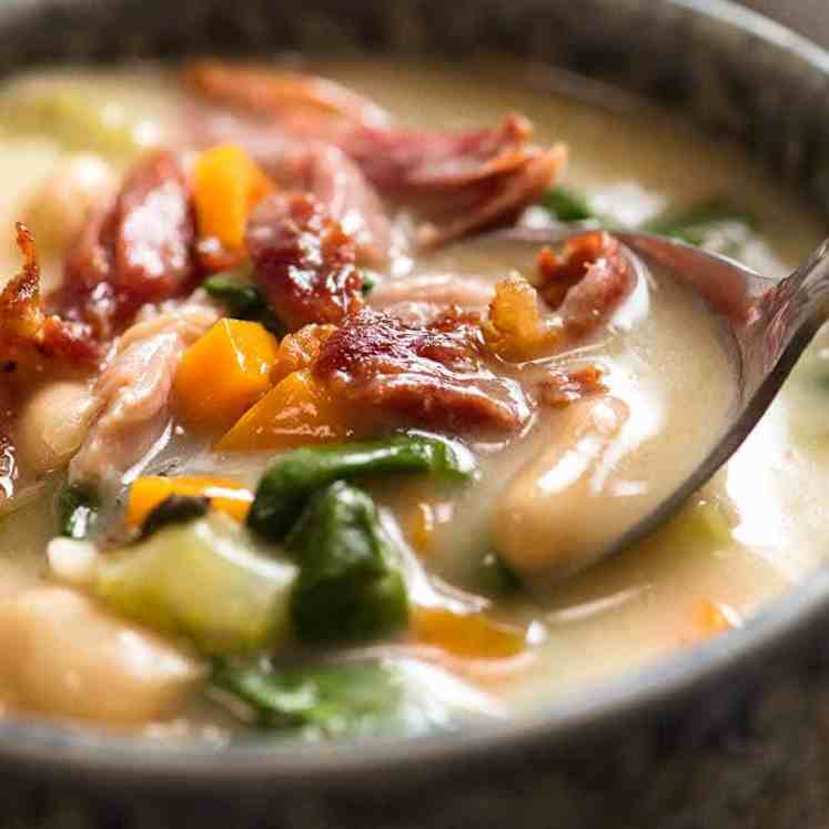 Close up of spoon dipping into bowl of Slow Cooker Ham Bone Soup with Beans