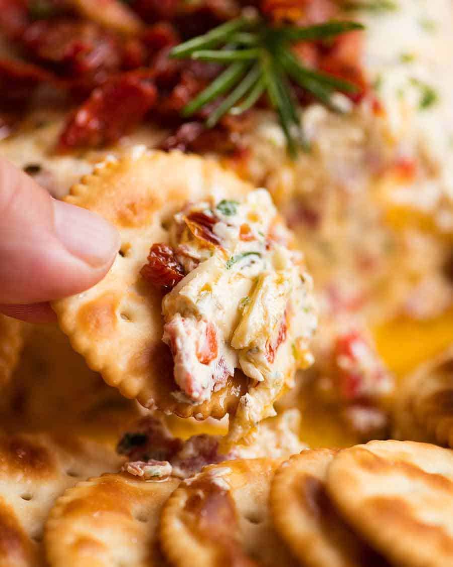 Close up of Christmas Appetiser Italian Cheese Log being scooped with cracker