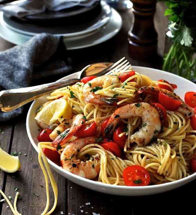 A bowl of Prawn Pasta with cherry tomatoes and lemon