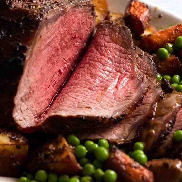 Sliced Marinated Roast Beef on a platter with roasted vegetables, ready to be served