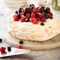 Pavlova decorated with cream and berries