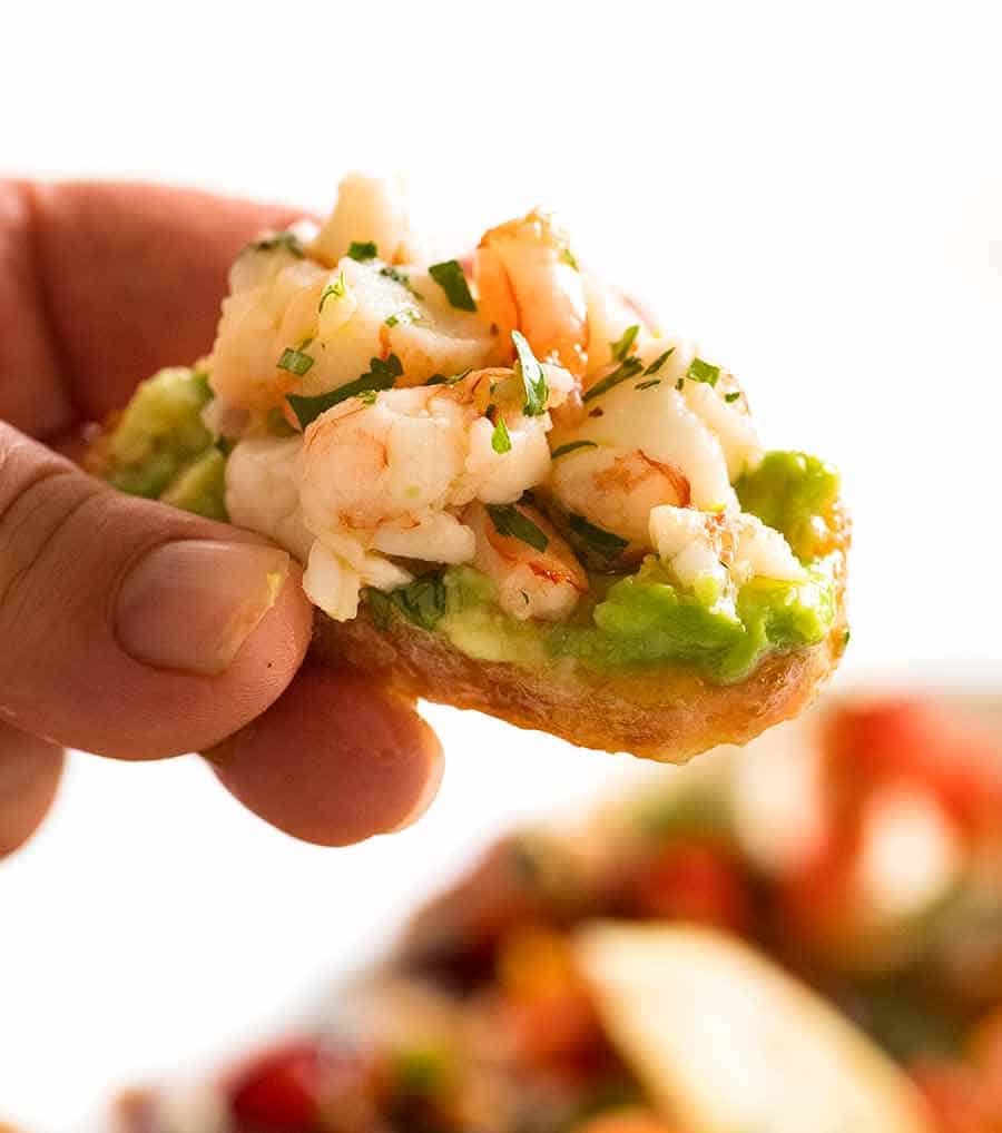 Close up of Prawn/Shrimp Avocado Crostini held by hand